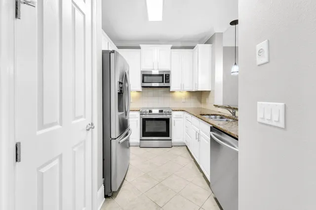 a kitchen with stainless steel appliances granite countertop a stove and a refrigerator