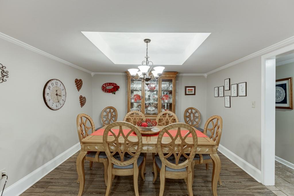 722 Charlie Morris Road Colbert, GA 30628 - Photo 19 of 78 a view of a dining room with furniture wooden floor and a chandelier