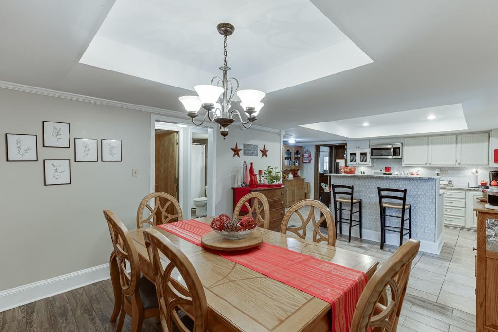 722 Charlie Morris Road Colbert, GA 30628 - Photo 21 of 78 a view of a dining room with furniture a chandelier and wooden floor