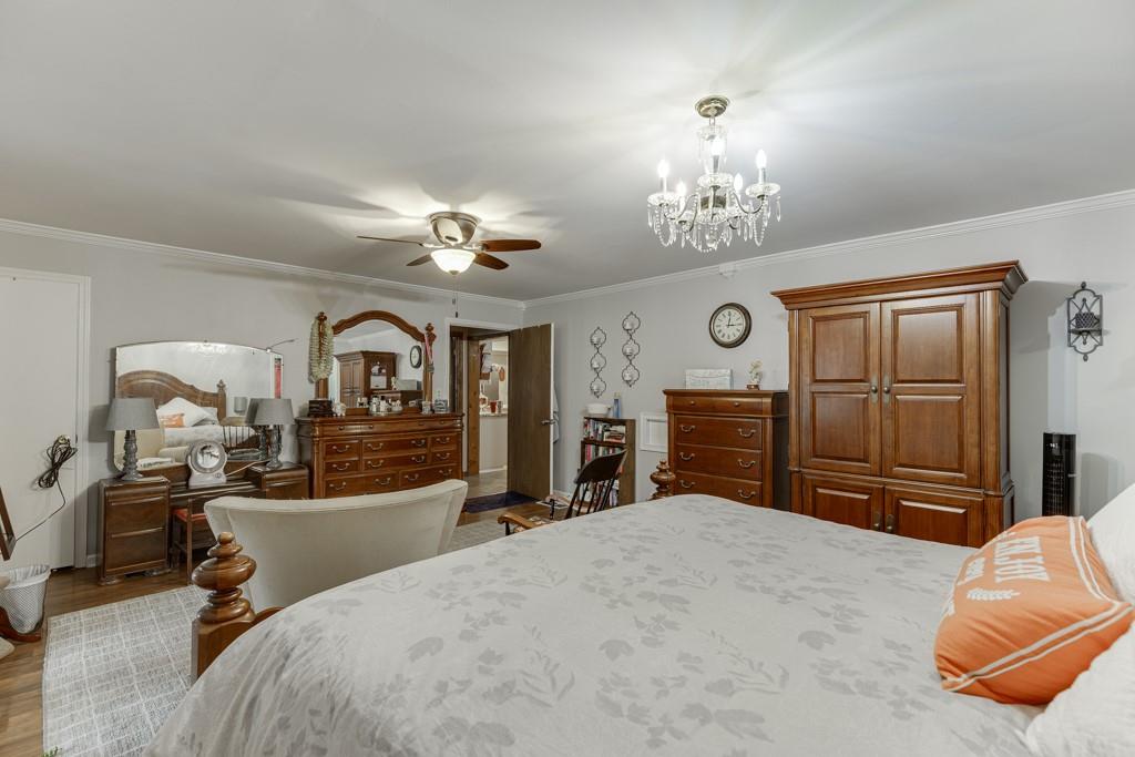 722 Charlie Morris Road Colbert, GA 30628 - Photo 27 of 78 a bedroom with a bed dresser and a chandelier