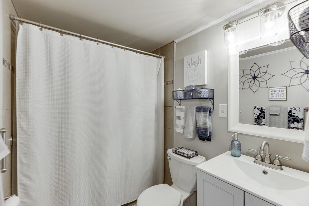 722 Charlie Morris Road Colbert, GA 30628 - Photo 39 of 78 a bathroom with a sink mirror and a toilet