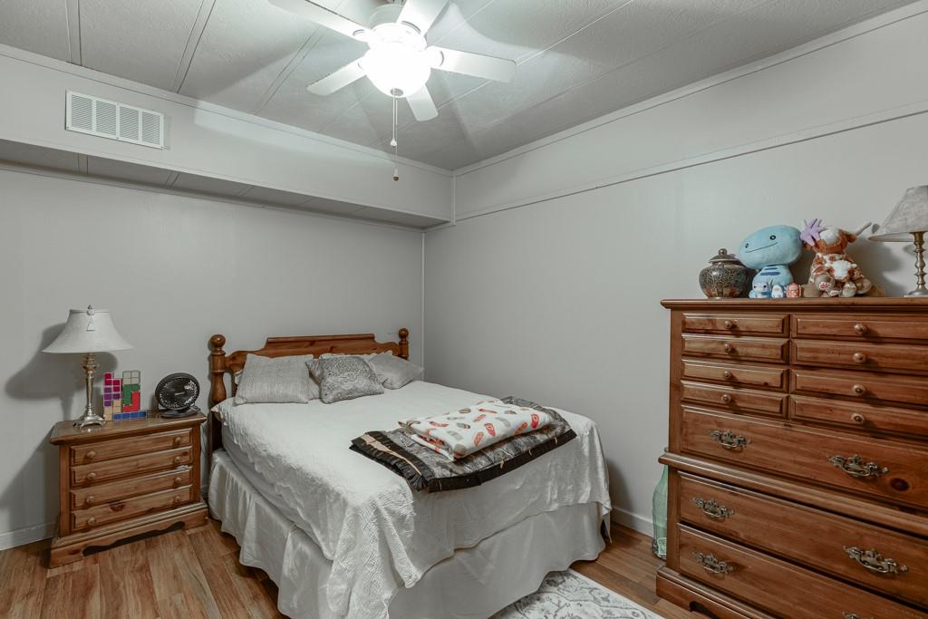 722 Charlie Morris Road Colbert, GA 30628 - Photo 52 of 78 a bedroom with a bed and a chandelier