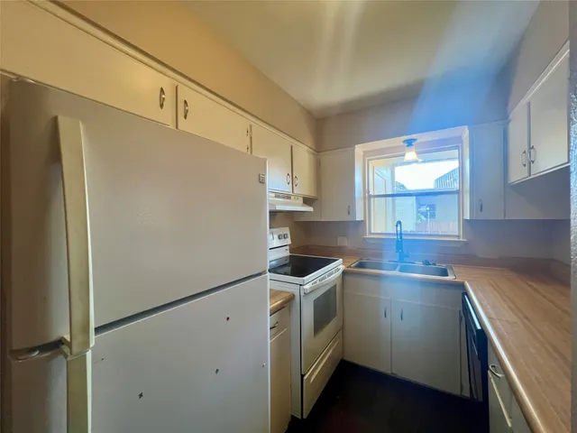 a kitchen with a refrigerator sink stove and cabinets