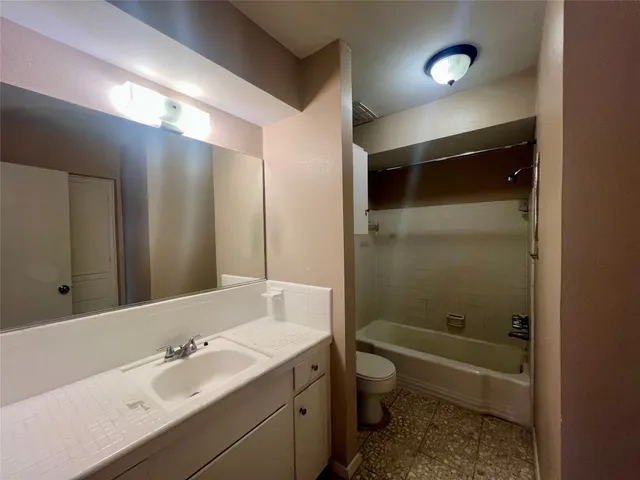a bathroom with a bathtub shower sink and toilet