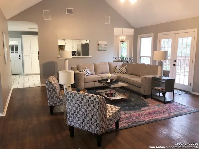 a living room with furniture wooden floor and a lamp