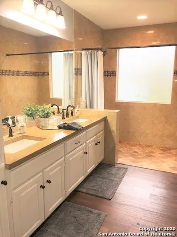 a spacious bathroom with sinks mirror and a bathtub