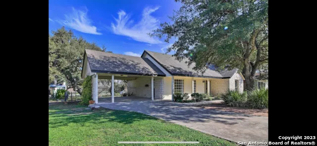 a view of a house with a yard and potted plants