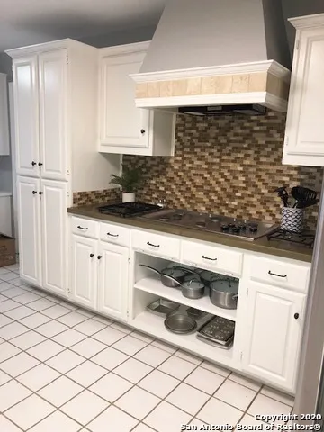 a kitchen with granite countertop white cabinets and white appliances