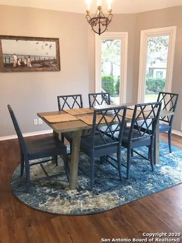 a dining room with furniture a rug and a painting
