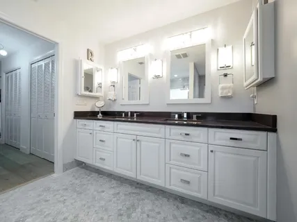 a spacious bathroom with a granite countertop sink and a mirror