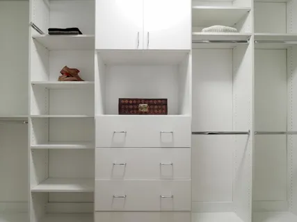 a bedroom with a large bed and a lamp on the dresser