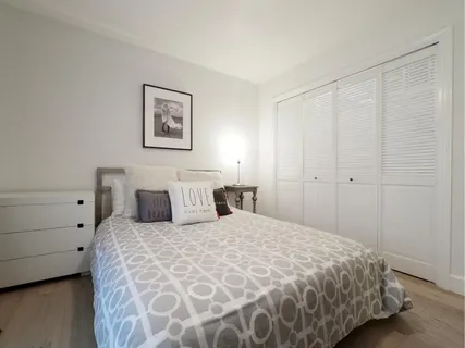 a bathroom with a granite countertop sink a toilet a large mirror and shower