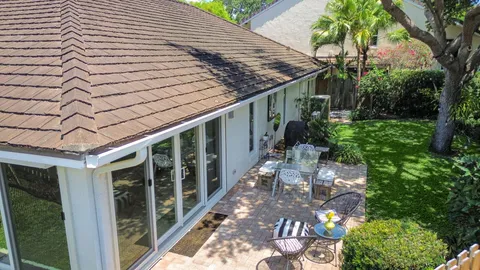 a view of a house with a yard and potted plants
