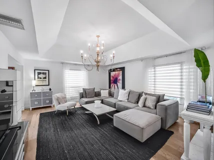 a living room with furniture or chandelier and a wooden floor