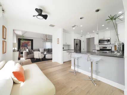 a living room with stainless steel appliances kitchen island furniture and a view of kitchen