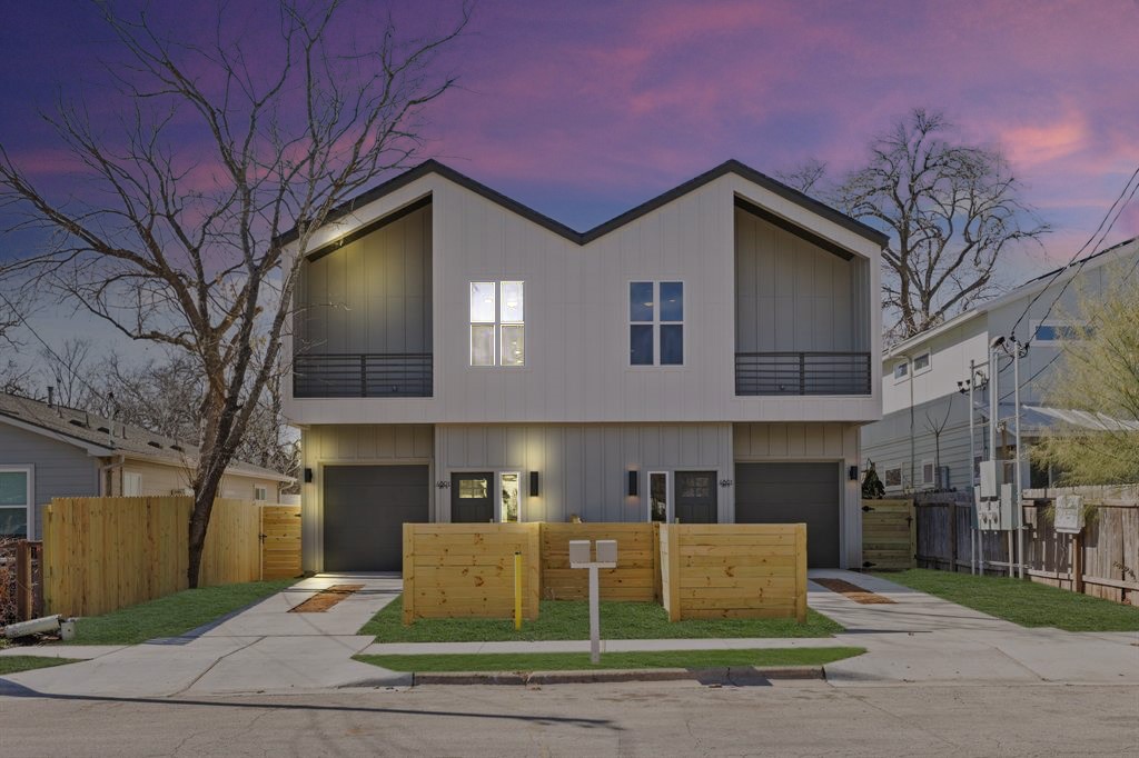 a view of a building with a yard and large trees