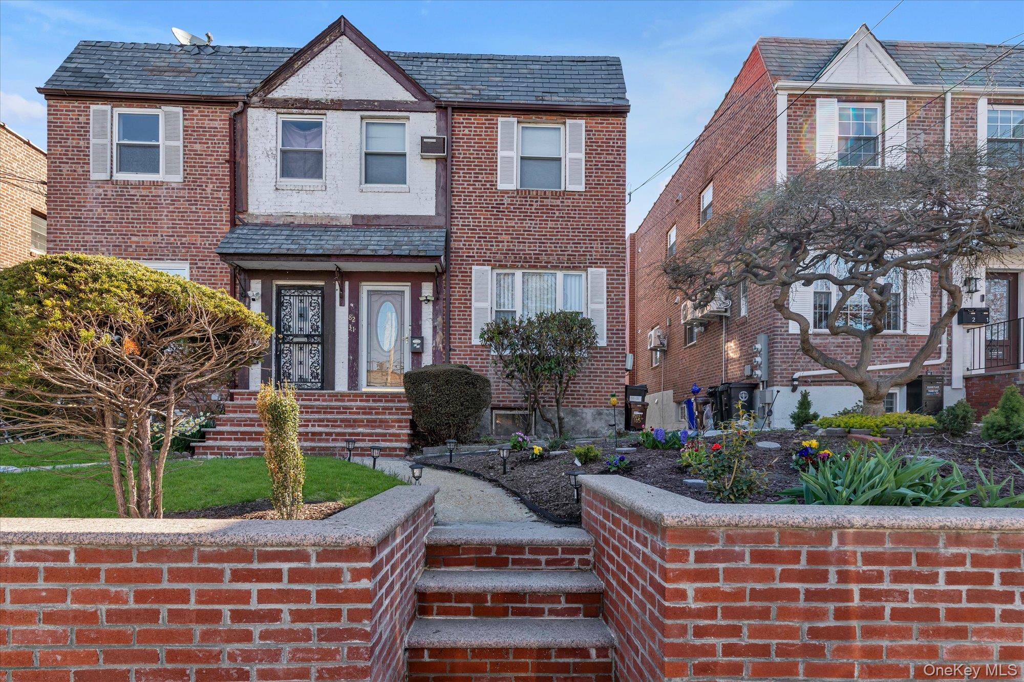 82-31 165th Street Queens, NY 11432 - Photo 1 of 16 a front view of a house with a garden