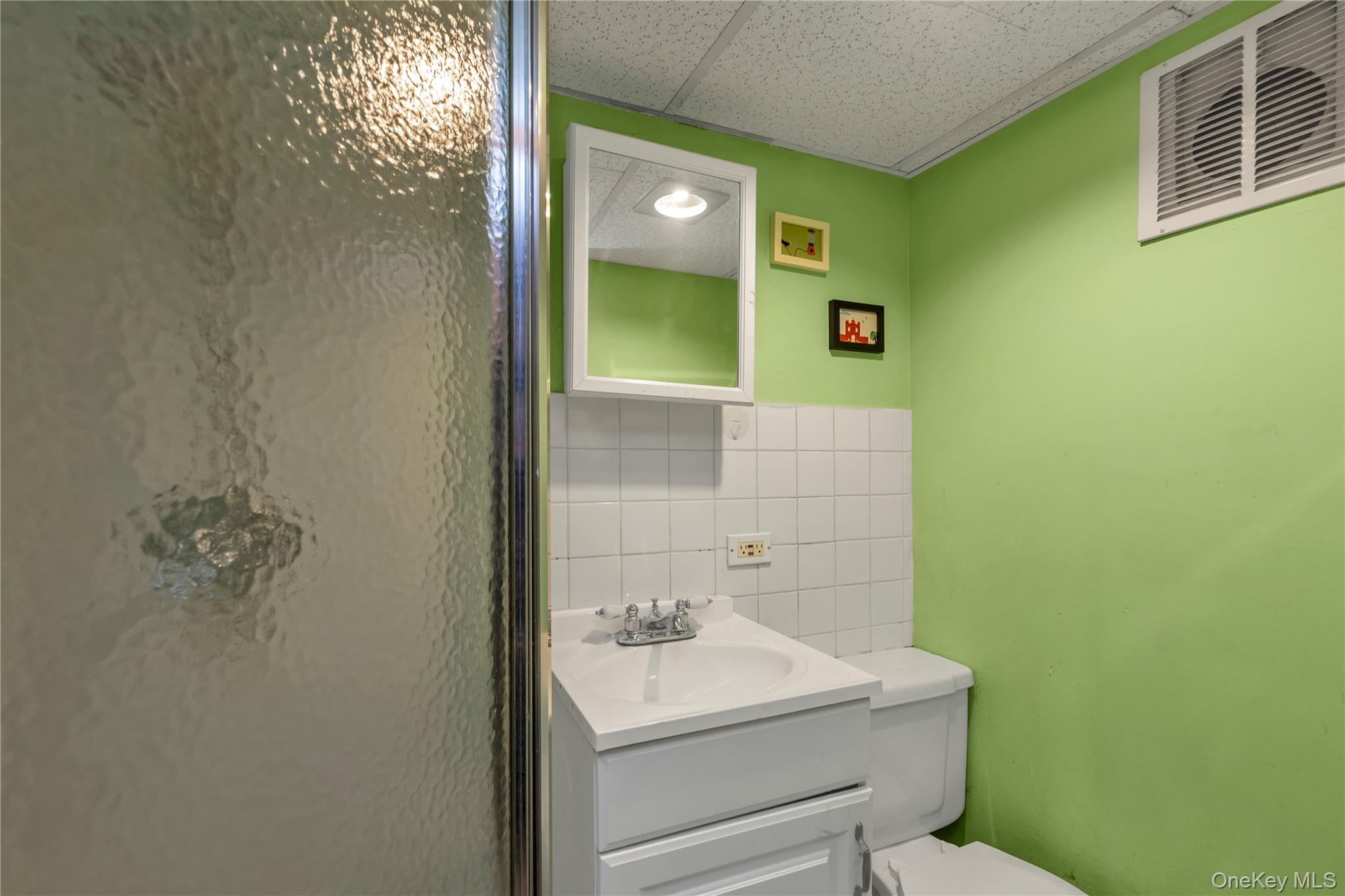 82-31 165th Street Queens, NY 11432 - Photo 14 of 16 a bathroom with a sink mirror and toilet