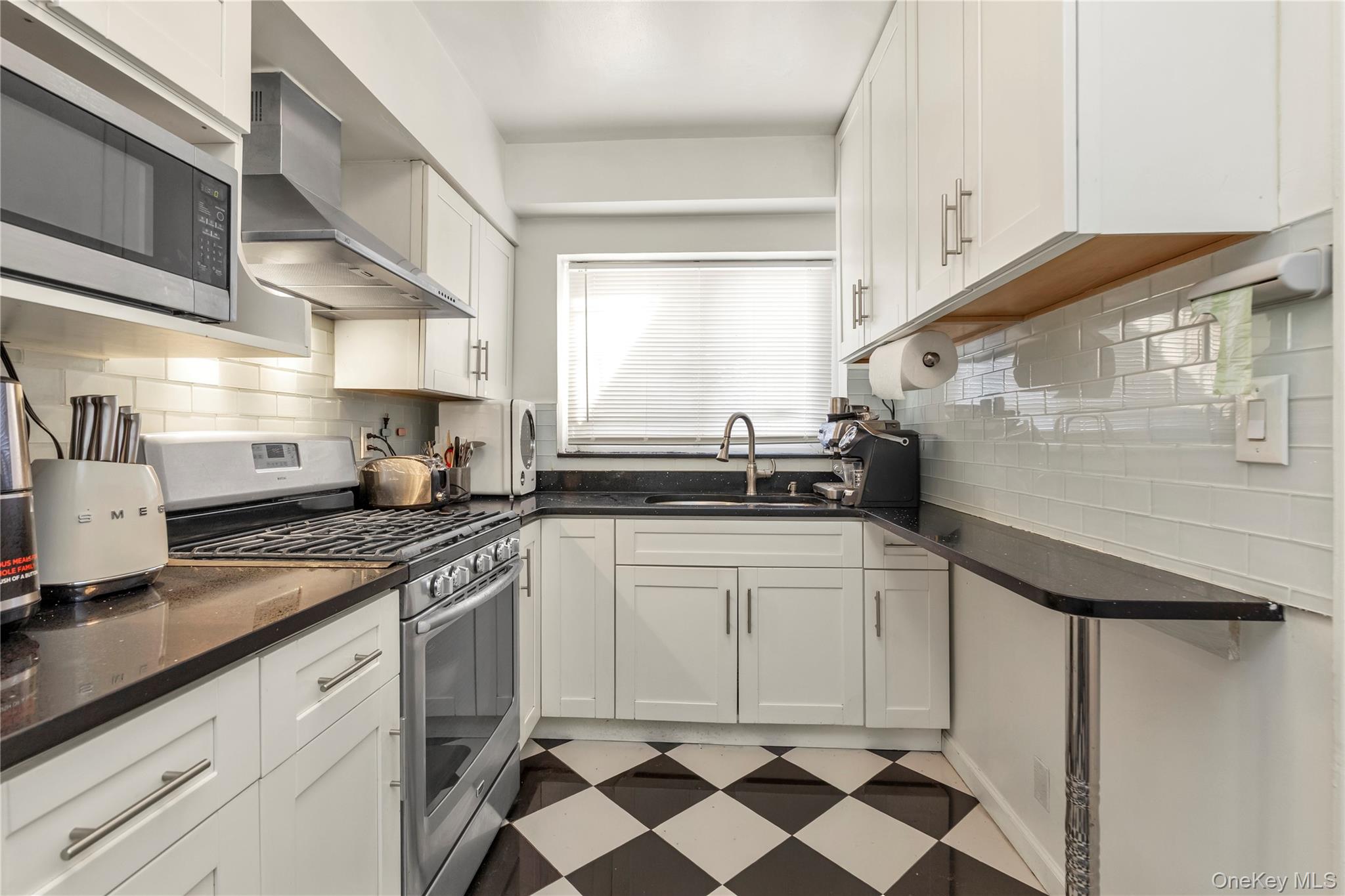 82-31 165th Street Queens, NY 11432 - Photo 5 of 16 a kitchen with stainless steel appliances a sink and cabinets