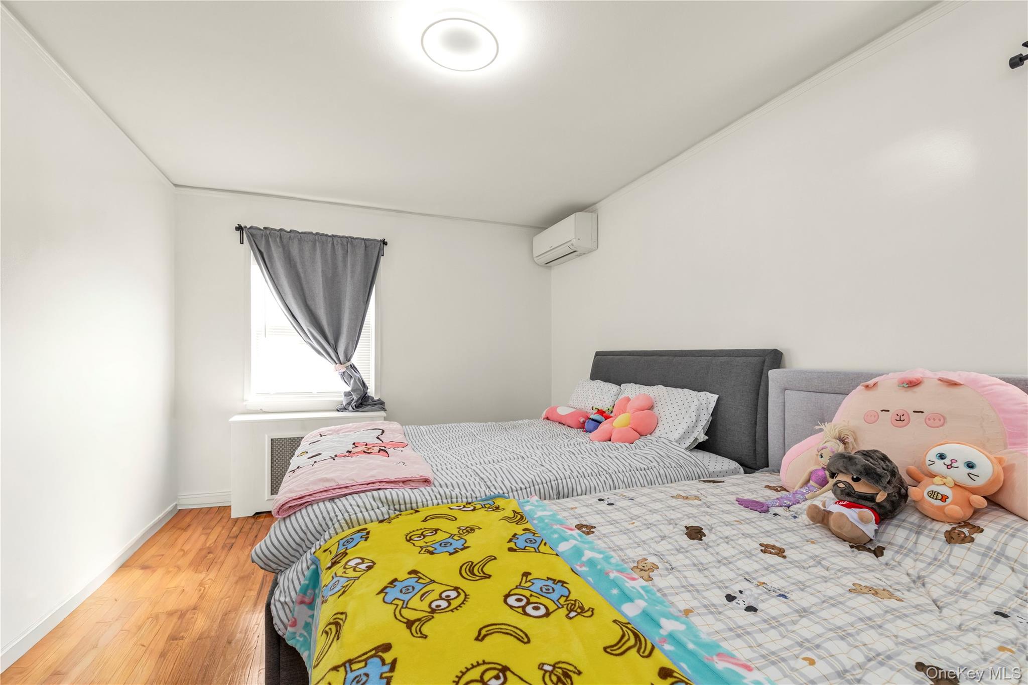 82-31 165th Street Queens, NY 11432 - Photo 8 of 16 a bedroom with two beds and a chandelier