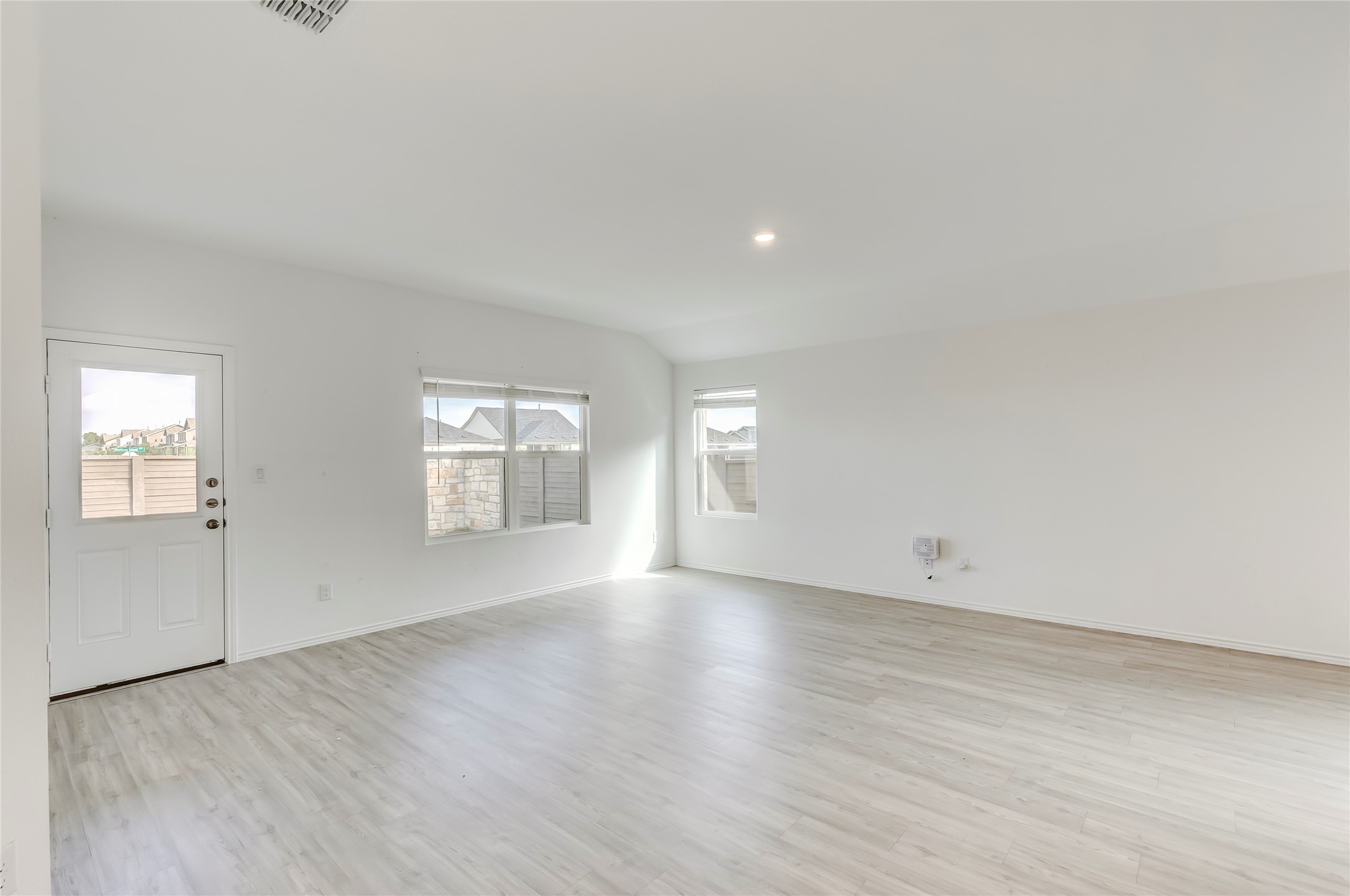 591 Avre Loop Kyle, TX 78640 - Photo 10 of 34 an empty room with wooden floor and windows