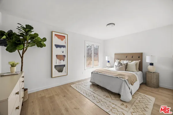 a bedroom with a large bed and a potted plant