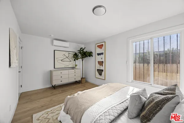 a bedroom with a bed and a large window