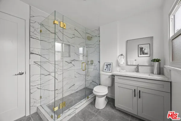a spacious bathroom with a granite countertop sink a toilet and shower