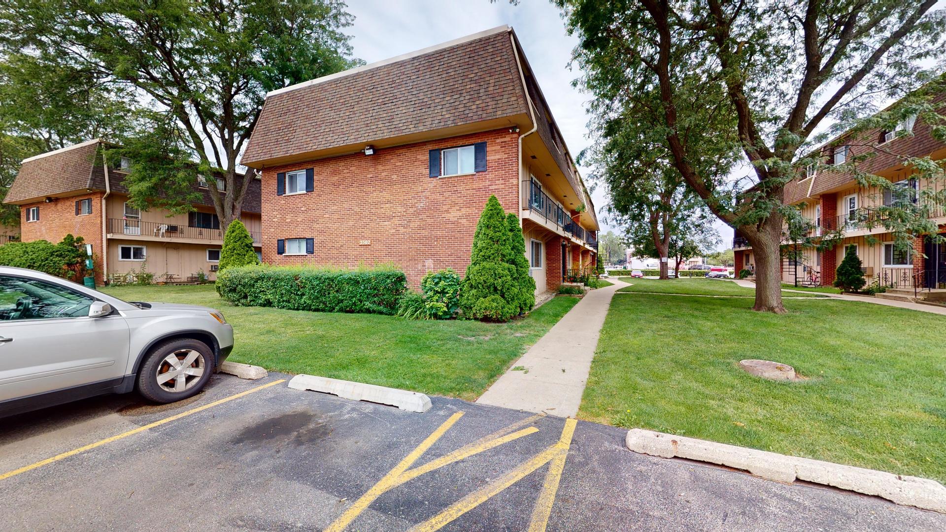 2302 West Algonquin Road, Unit 12 Rolling Meadows, IL 60008 - Photo 2 of 22 a front view of a house with a garden