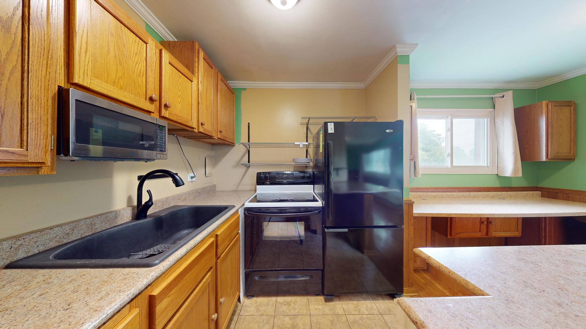 2302 West Algonquin Road, Unit 12 Rolling Meadows, IL 60008 - Photo 9 of 22 a kitchen with stainless steel appliances granite countertop a sink a stove and refrigerator