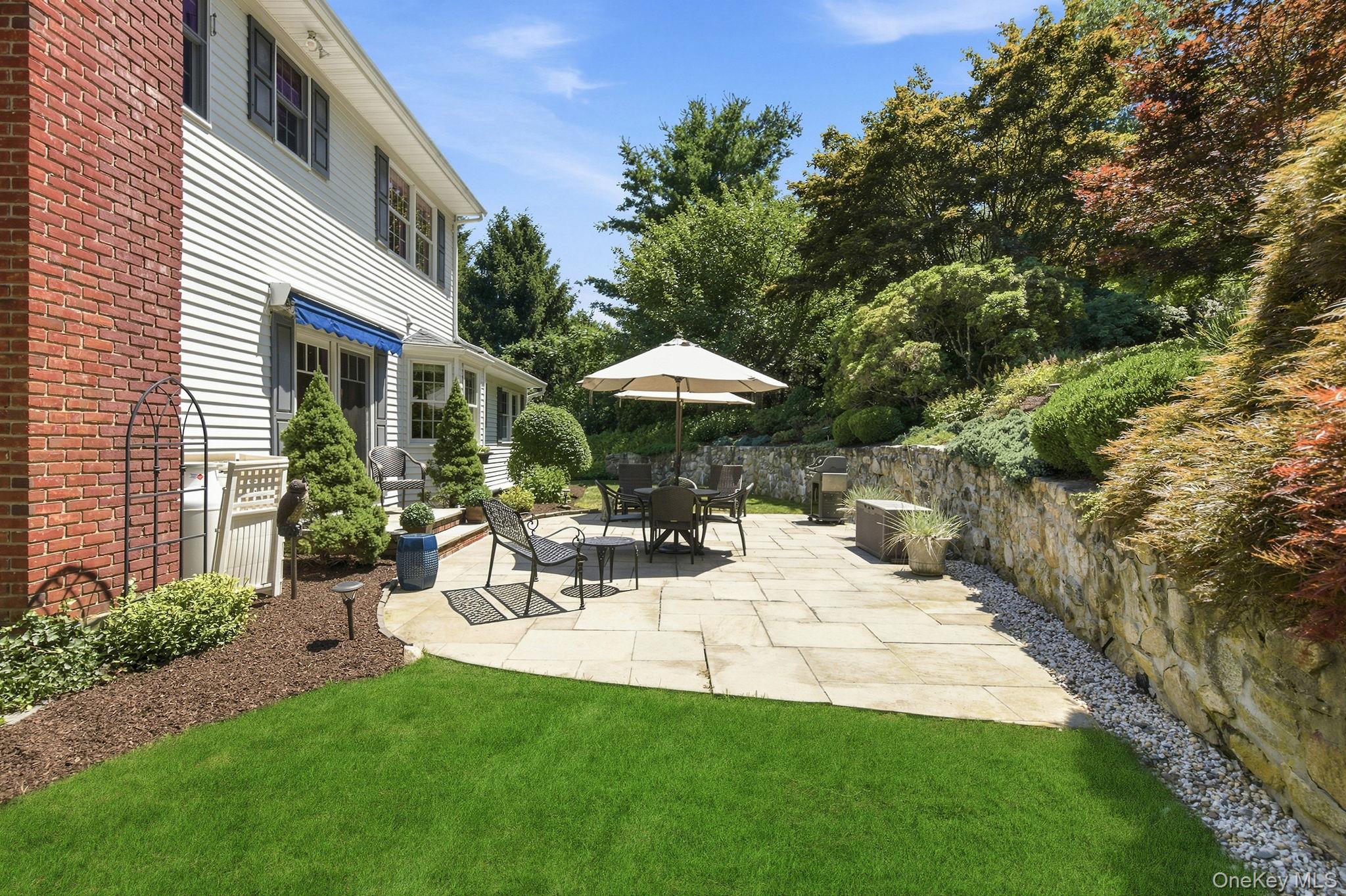 32 Bedell Road Katonah, NY 10536 - Photo 31 of 49 A stone-walled side patio sits just off the awning-covered entry door.