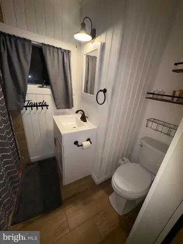 a bathroom with a sink a toilet a mirror and shower