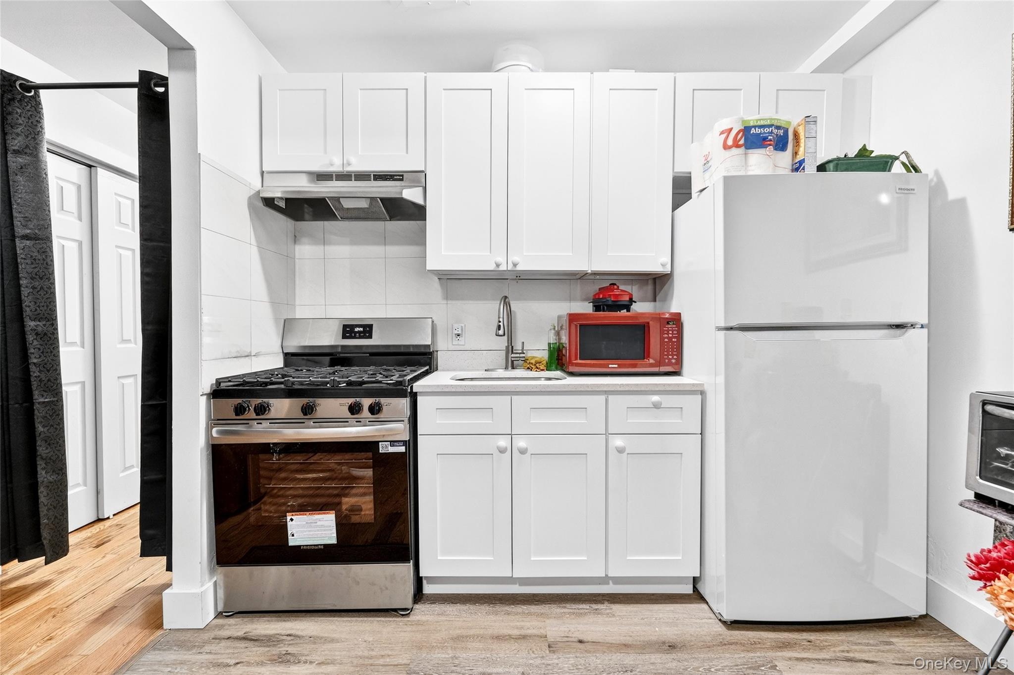 1459 Rosedale Avenue Bronx, NY 10460 - Photo 25 of 37 Kitchen featuring freestanding refrigerator, stainless steel range with gas stovetop, light countertops, and white cabinetry