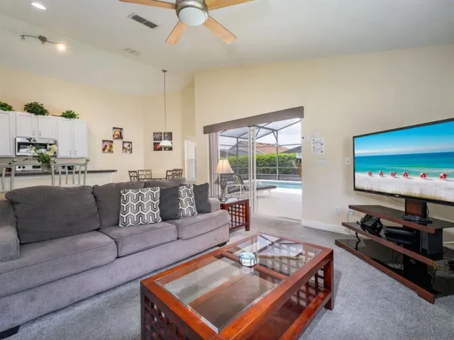 a living room with furniture a flat screen tv and a window