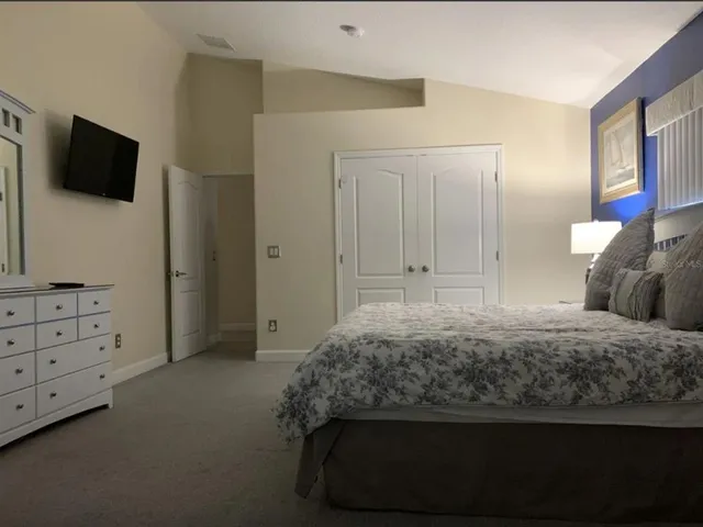 a bedroom with a bed and a flat screen tv