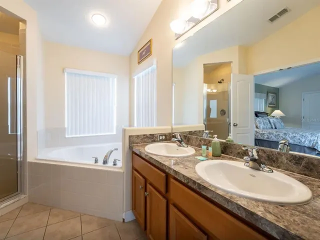 a bathroom with a granite countertop sink and a bathtub