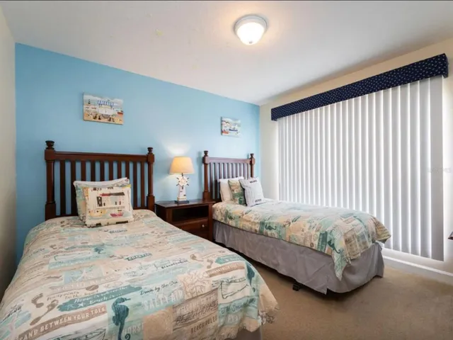 a bedroom with two beds and a large window