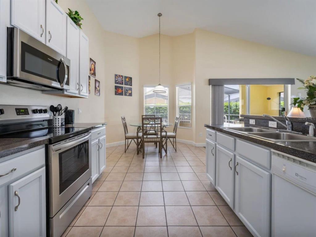 641 Old Bridge Circle Davenport, FL 33897 - Photo 9 of 28 a kitchen with stainless steel appliances a stove sink microwave and cabinets