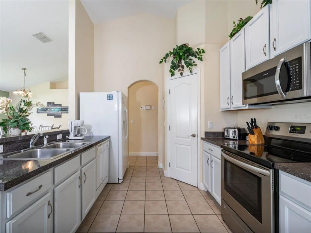 641 Old Bridge Circle Davenport, FL 33897 - Photo 10 of 28 a kitchen with stainless steel appliances a sink stove and cabinets