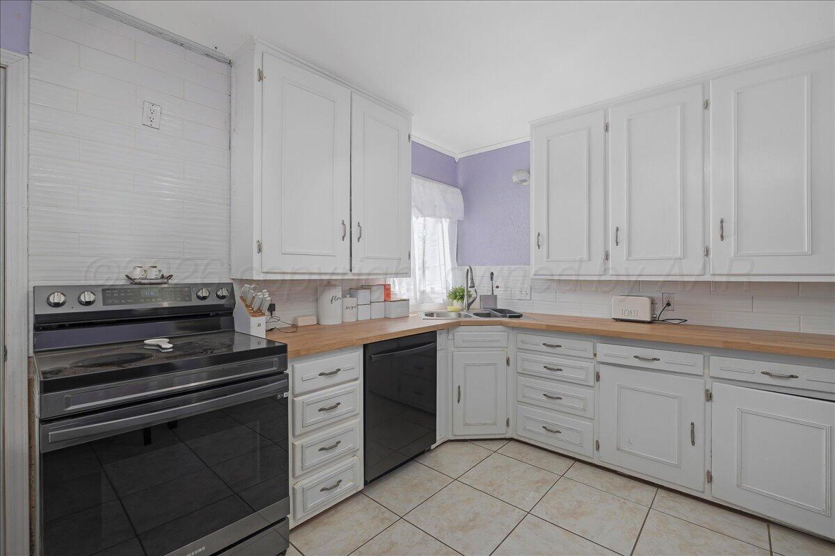 4011 Parker Street Amarillo, TX 79110 - Photo 6 of 17 a kitchen with white cabinets and sink