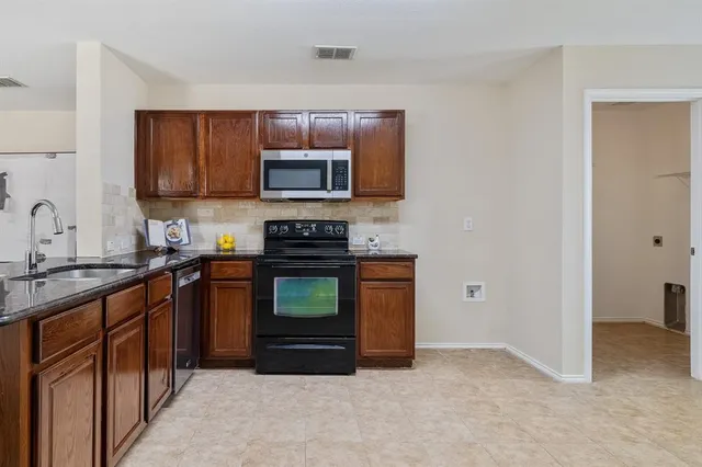 a kitchen with stainless steel appliances a stove microwave and sink
