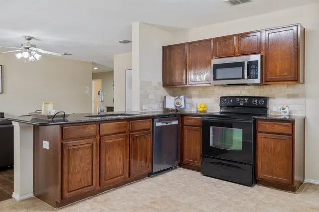 a kitchen with stainless steel appliances granite countertop a stove microwave and sink