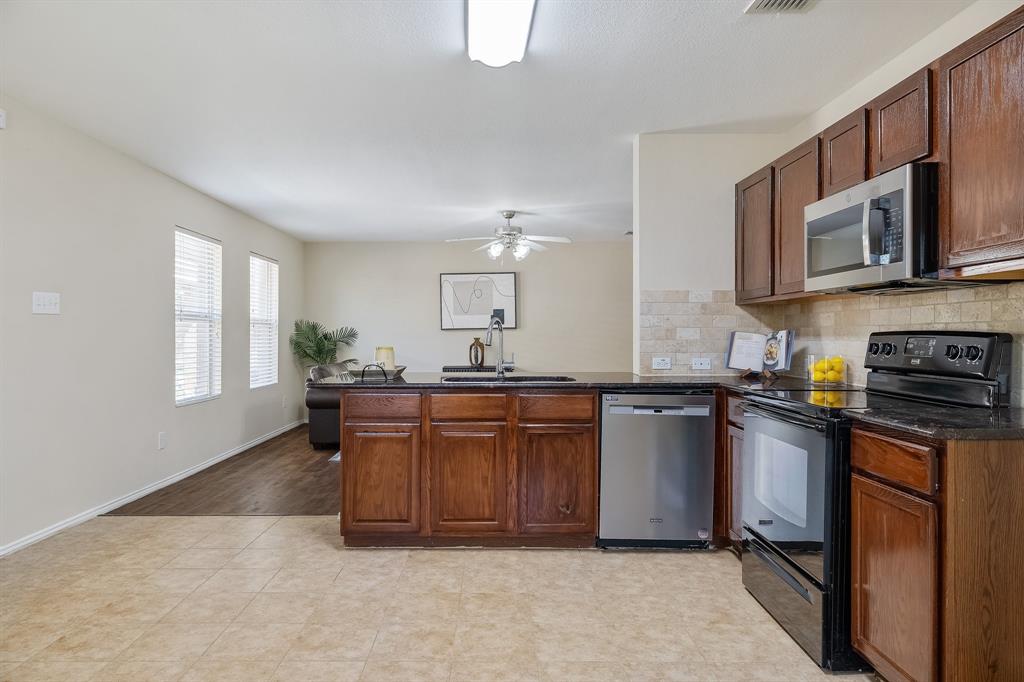 5016 Pacific Way Frisco, TX 75036 - Photo 14 of 24 a kitchen with stainless steel appliances granite countertop a stove a sink dishwasher and a microwave oven with white cabinets