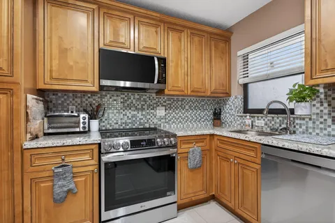 a kitchen with stainless steel appliances granite countertop a sink stove and microwave