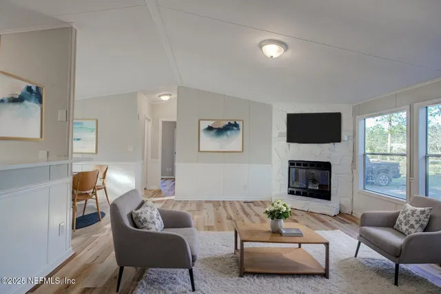 a living room with furniture a fireplace and a flat screen tv