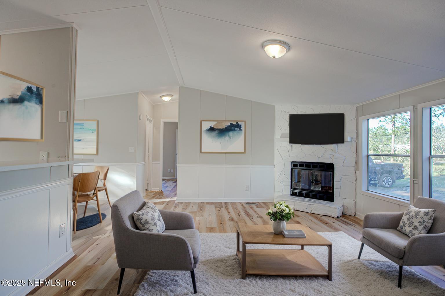 5175 Carter Spencer Road Middleburg, FL 32068 - Photo 2 of 41 a living room with furniture a fireplace and a flat screen tv