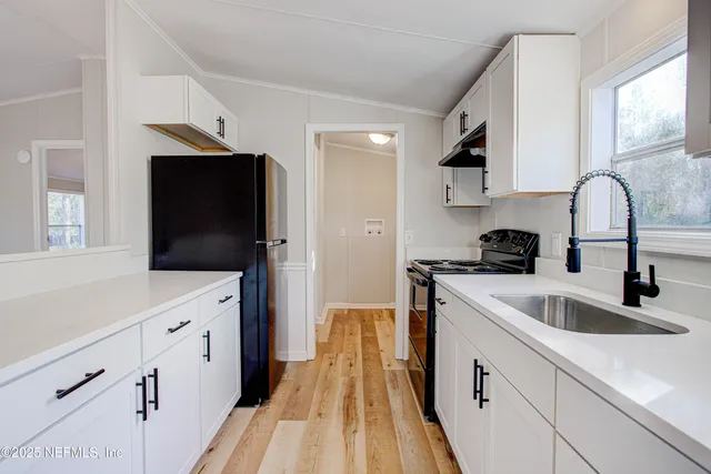 a kitchen with cabinets a sink and appliances