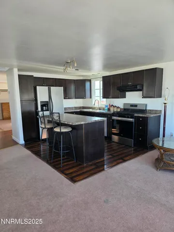 a kitchen with kitchen island a sink stove and microwave