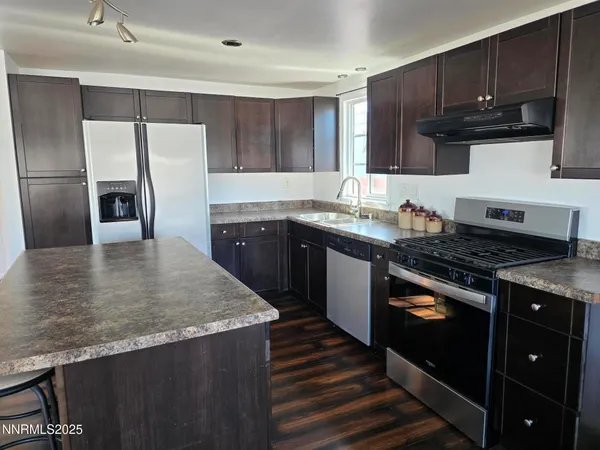 a kitchen with stainless steel appliances granite countertop a stove a refrigerator and a sink