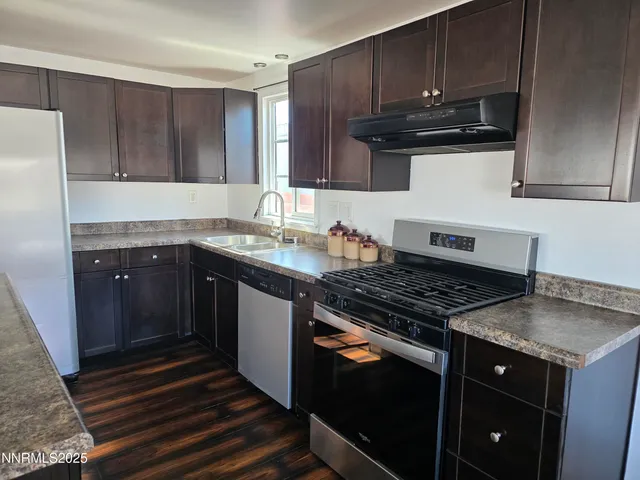 a kitchen with granite countertop a stove and a sink